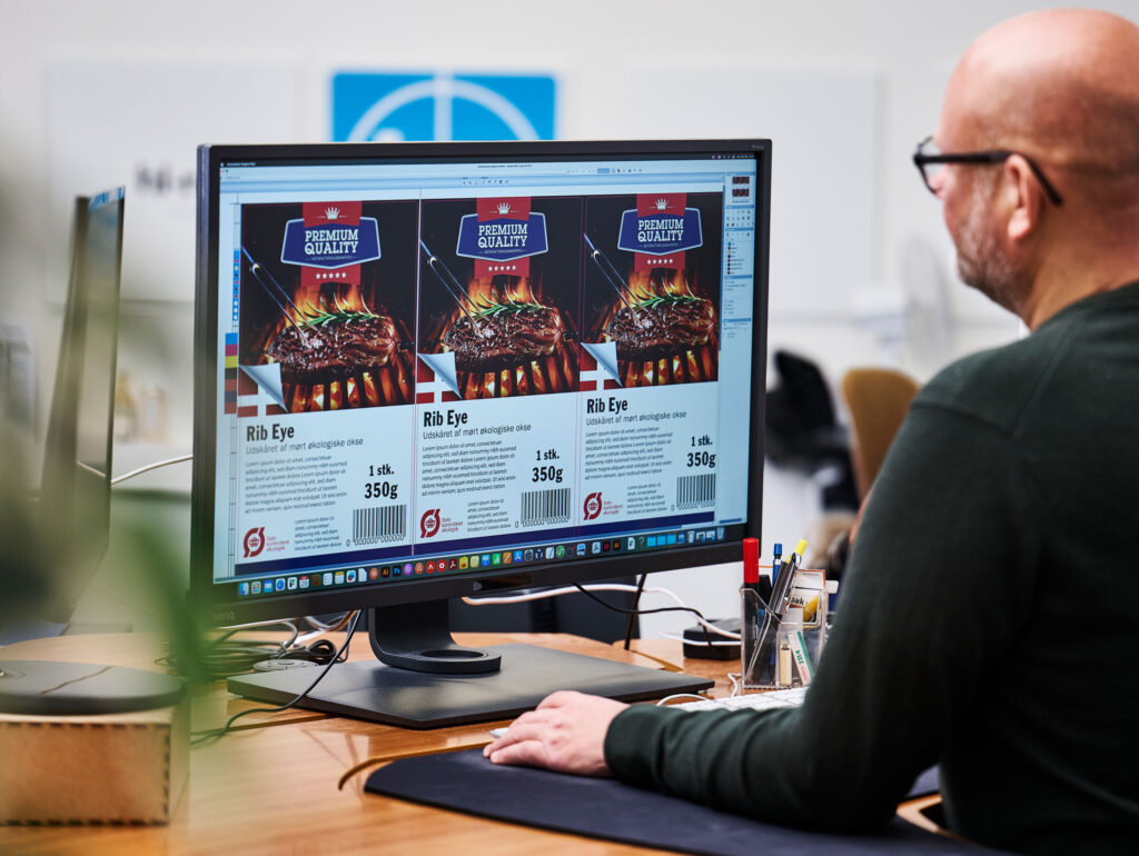 Der arbejdes på computeren med en etiket i hl-repros label-afdeling.