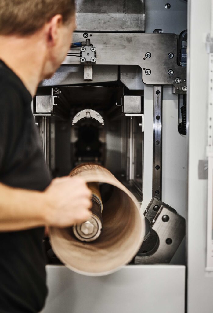 Medarbejder hos hl-repro er ved at montere en polymer sleeve. Vi var de første i verden, som havde denne type produktion af kemifrie sleeves.